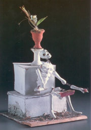 Photograph of skeleton holding book.